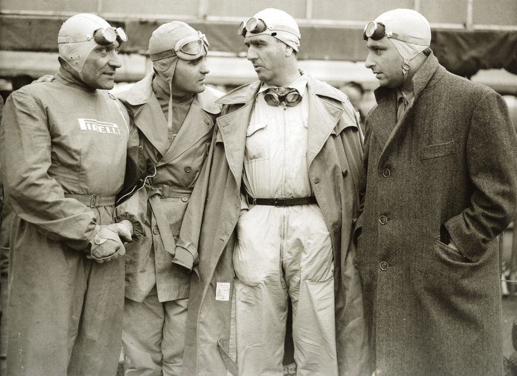 The pilots of the early F1, with coveralls, goggles and aviator helmets. 
