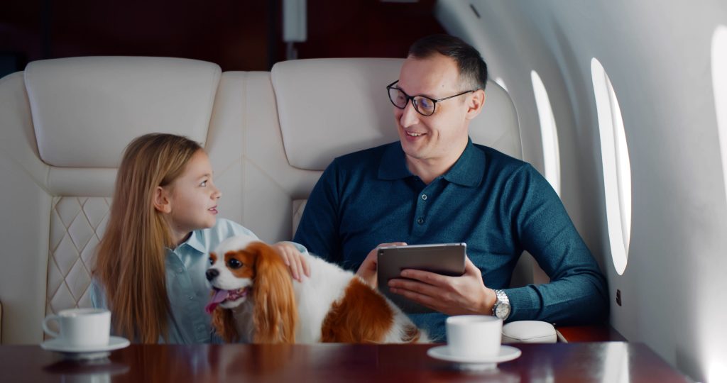 photo of a father and daughter with their dog on a jet.