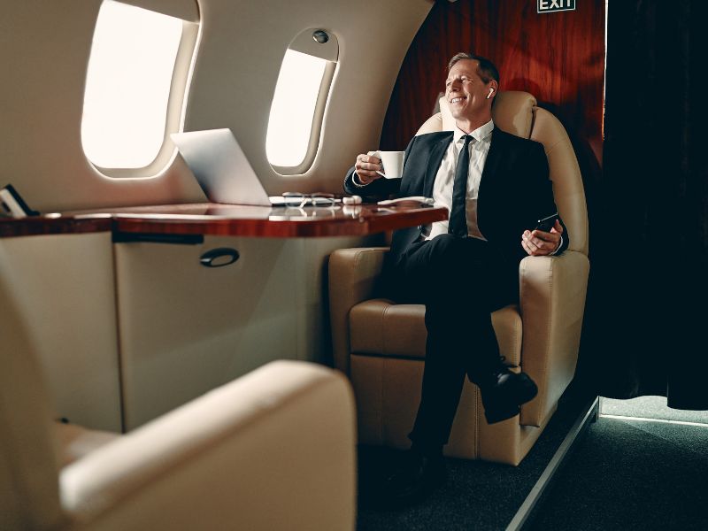 man having cup of coffee on private jet