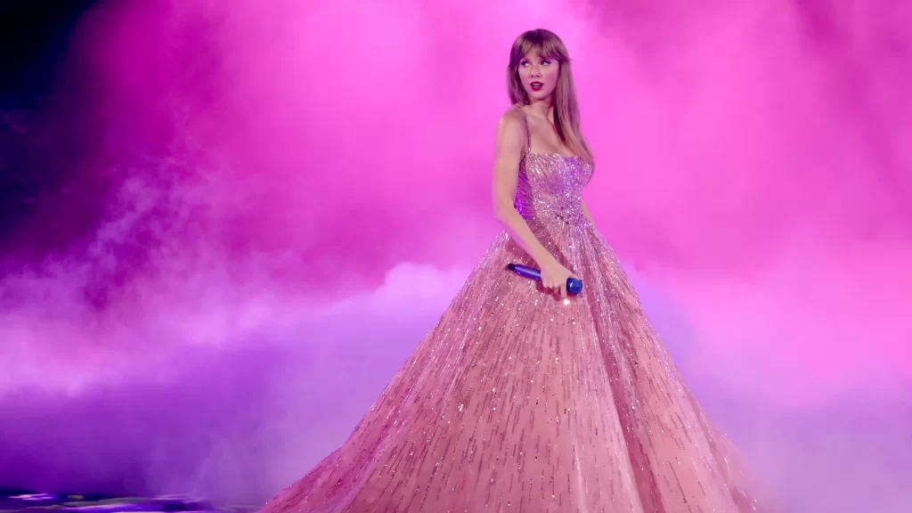 Taylor Swift on stage wearing a pink dress.