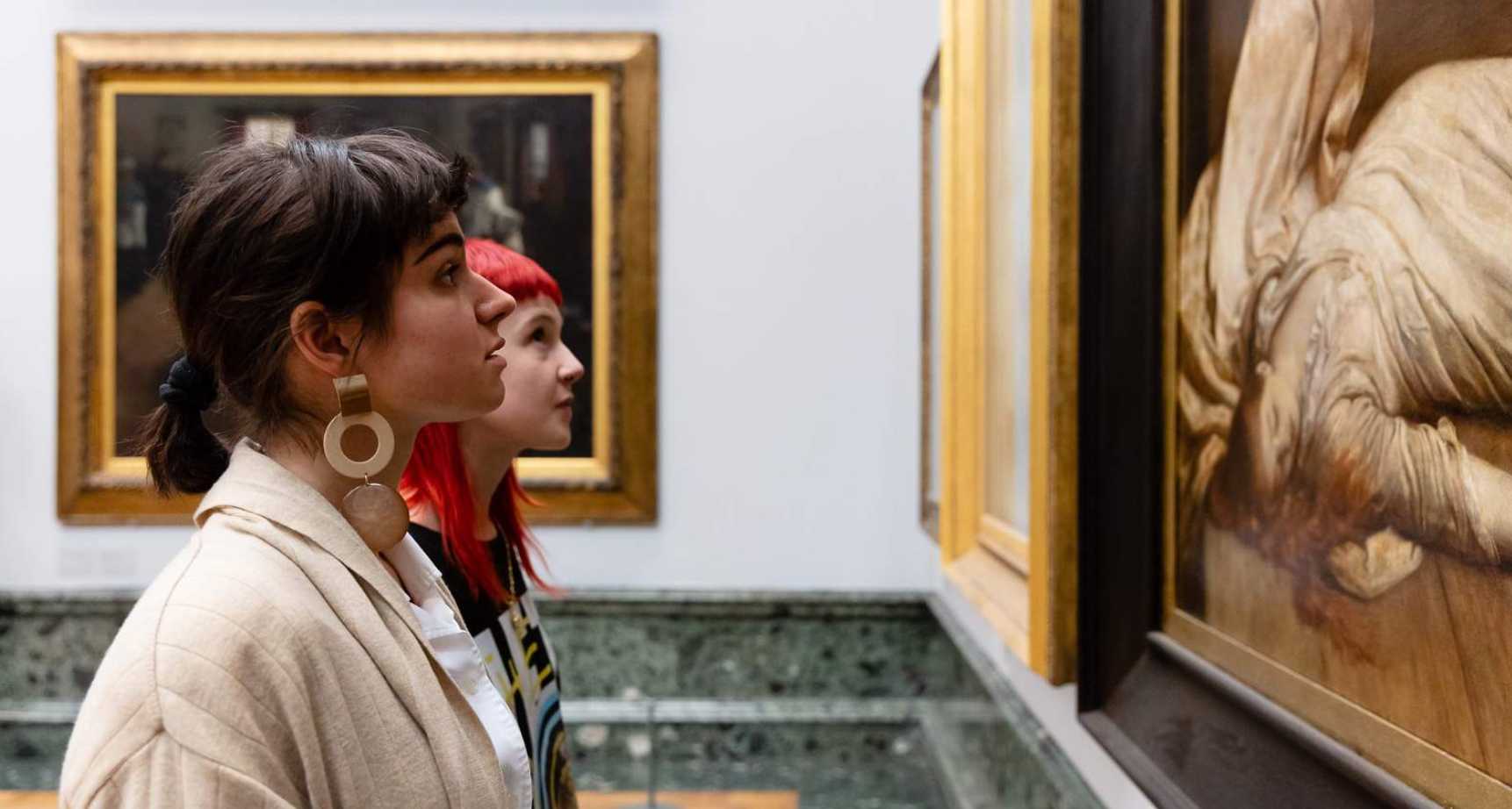 Two girls looking at a painting