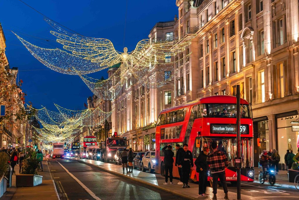 Street view of Traditional buildings in London illuminated by Christmas angel decorations at dusk